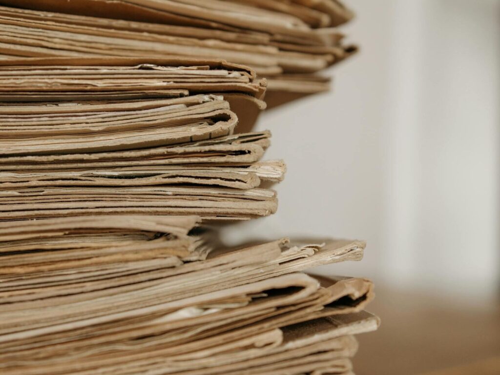 Close-up of vintage paper stacks on a wooden table, evoking a classic office setting.